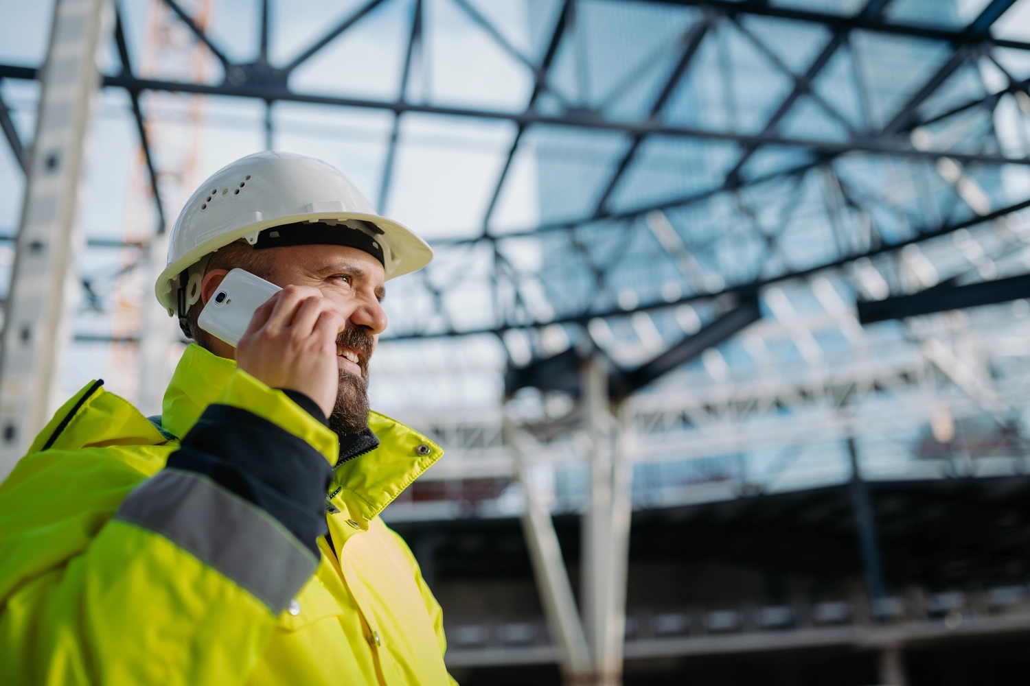 NEXLINK GmbH - Bauconsulting I Projektmanagement - Bauleiter telefoniert während der Baustelleninspektion.